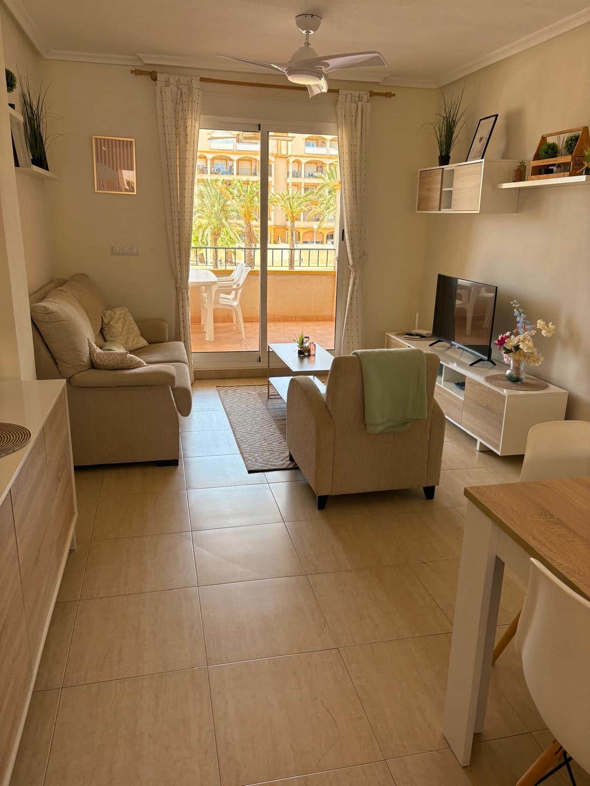 Salón de Cheyu con balcón y palmeras en el exterior